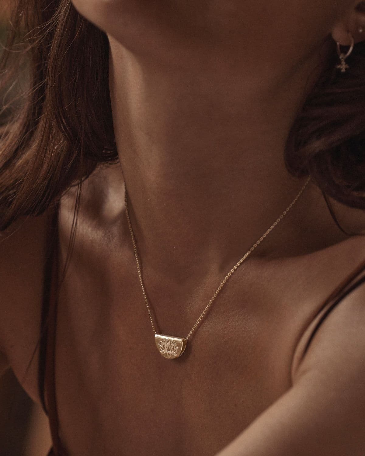 Campaign/editorial image styling the Lotus Necklace, from the product page gallery
