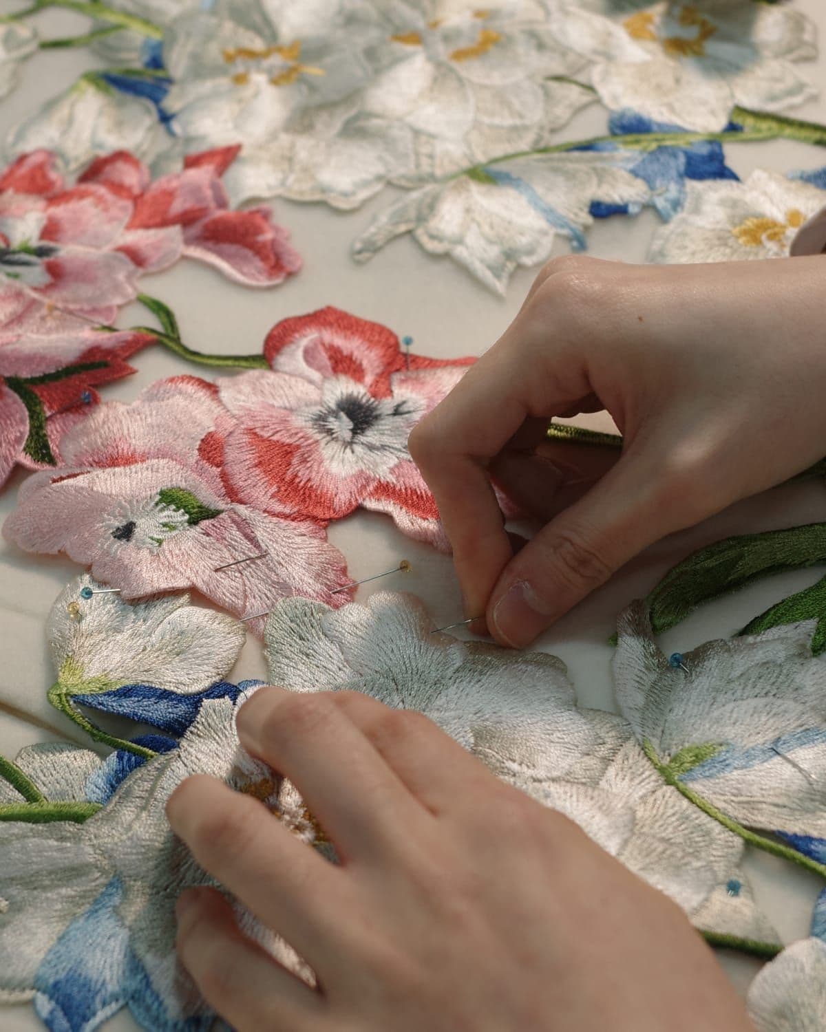 Close-up editorial detail shot illustrating garment craftsmanship, 'The Art of Design' section