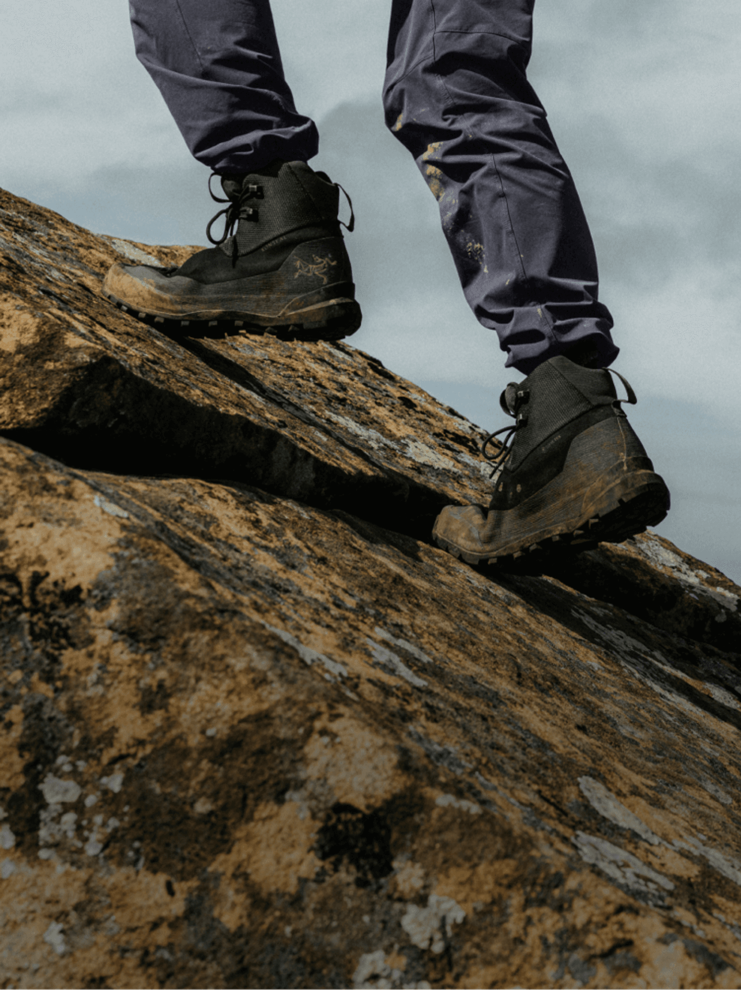 Arc'teryx hiking boots on lichen-covered granite, from the official Arc'teryx campaign