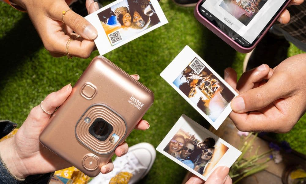 Friends sharing printed Instax mini LiPlay photos outdoors