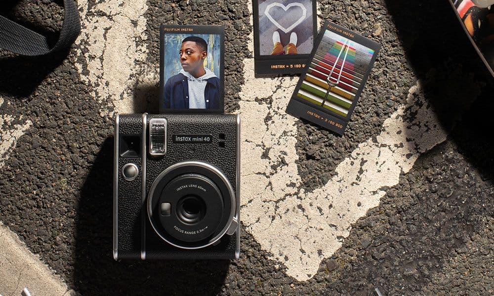 Instax mini 40 camera with printed photos on a textured surface
