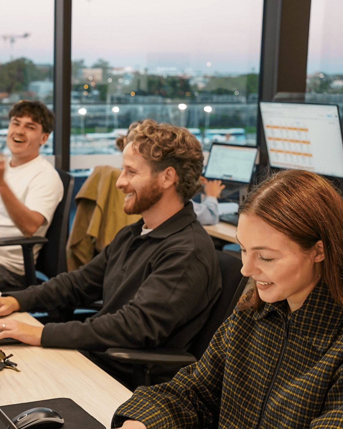 Three specialists mid-laugh at the desks