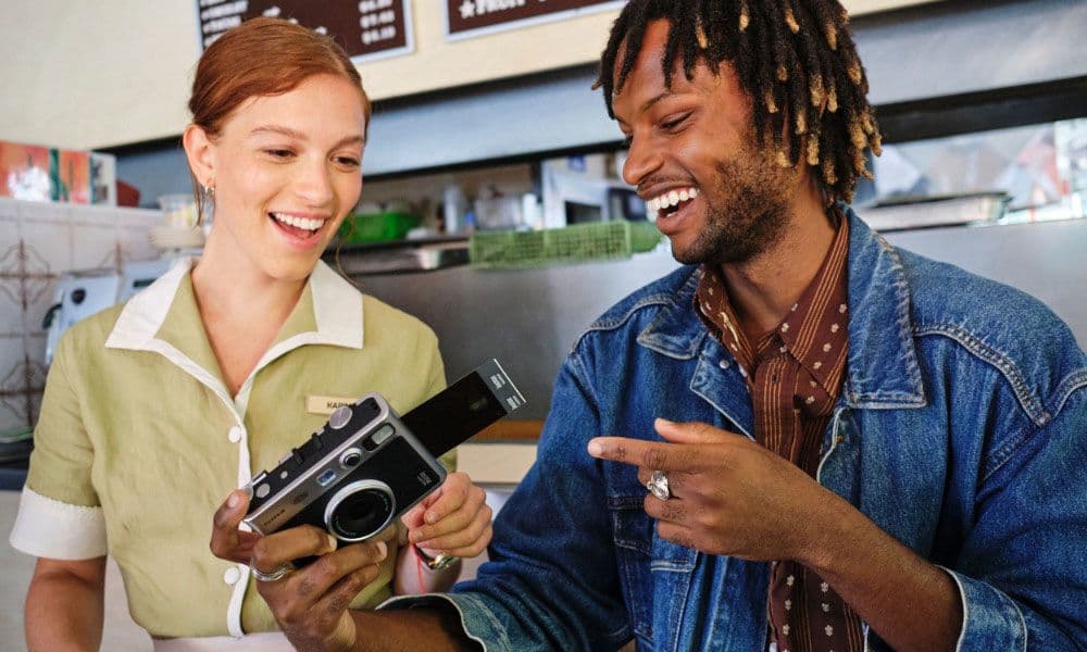 Two people laughing together while reviewing an Instax mini Evo photo