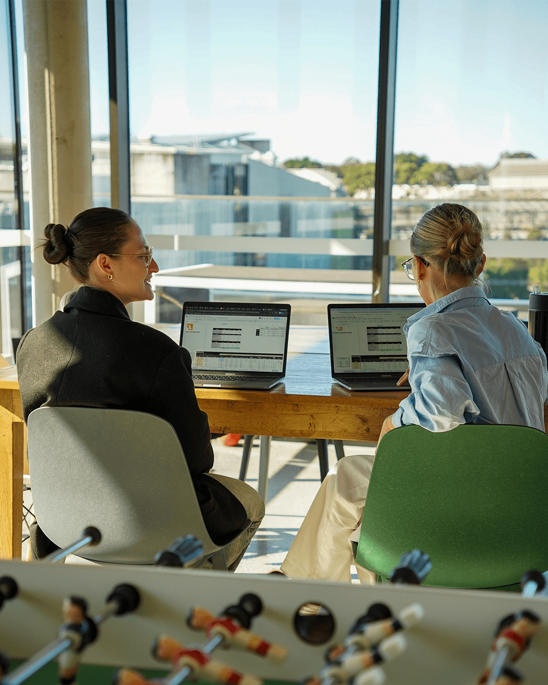 Two specialists at the desks, floor-to-ceiling windows behind