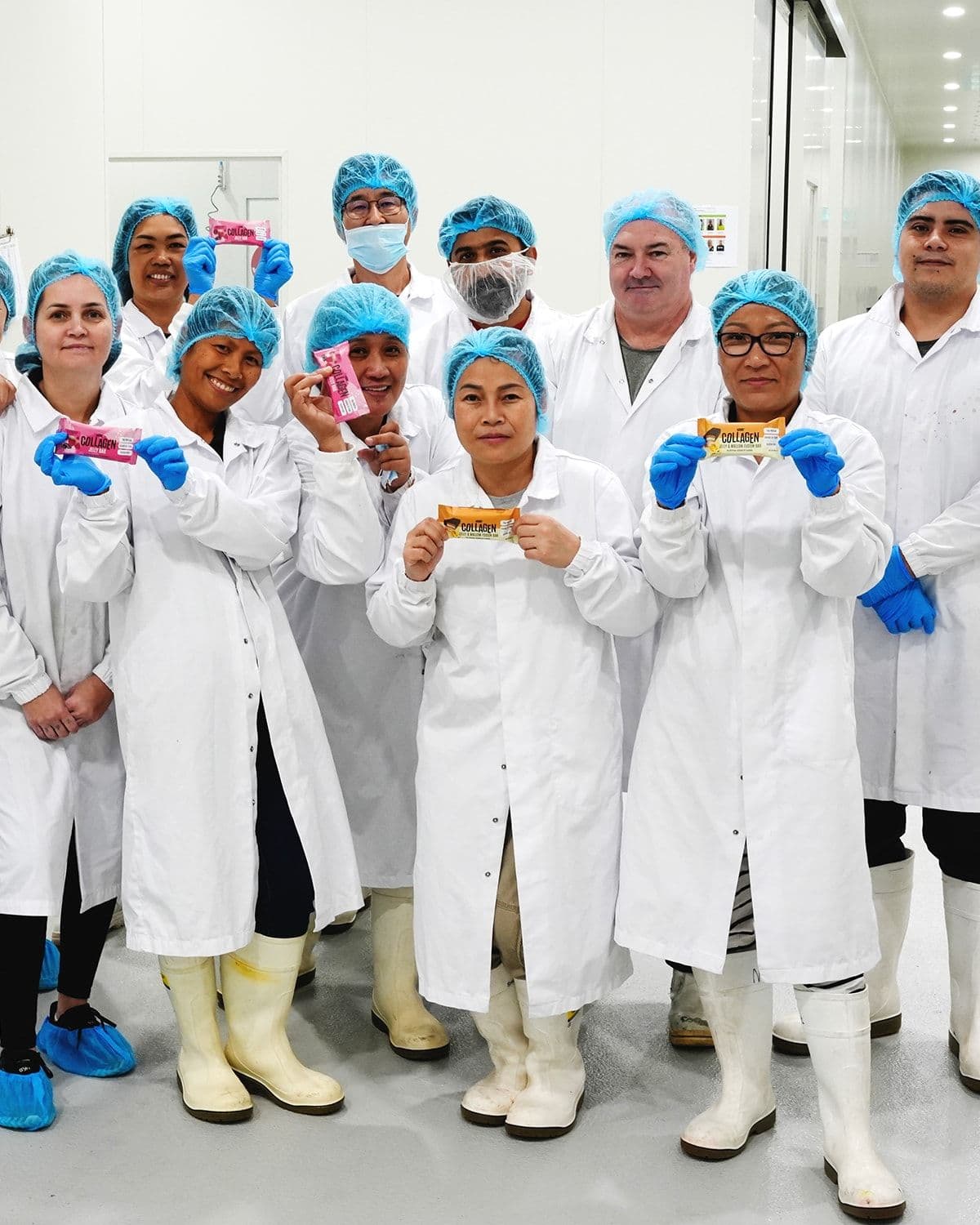 ATP Science production staff in hairnets and lab coats holding NOWAY! Collagen bars in the Brisbane facility
