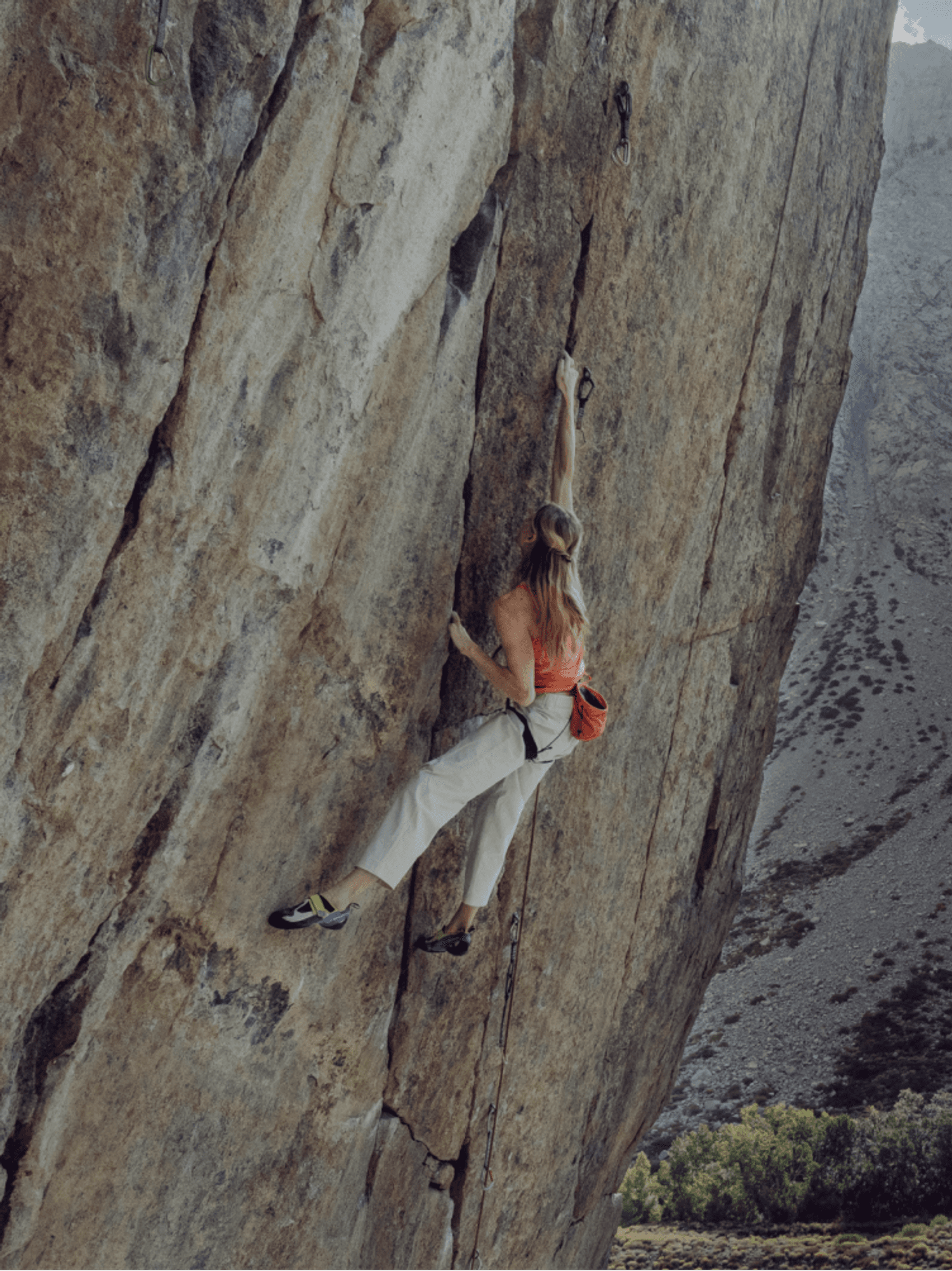Rock climber reaching for a hold on a sheer granite face, from the official Arc'teryx campaign