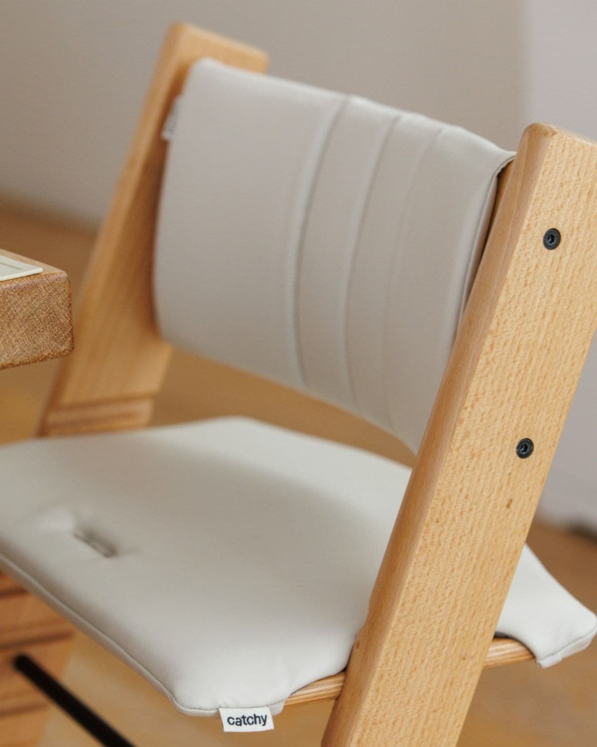 Catchy cushion set detail on a Stokke Tripp Trapp chair beside a dining table with avocado bowl